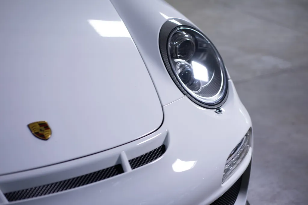 The gloss on the front of a white Porsche 911 after ceramic coating.