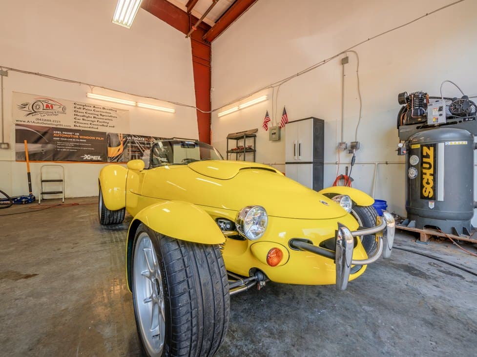 A yellow roadster in the A1 bay during protection work.
