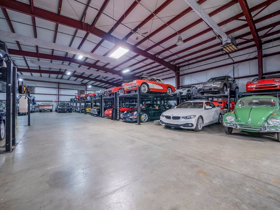 Wide view of the A1 storage floor, with rows of collector cars on two-level racks under a red steel roof.